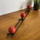 Coat rack with 3 red wooden balls