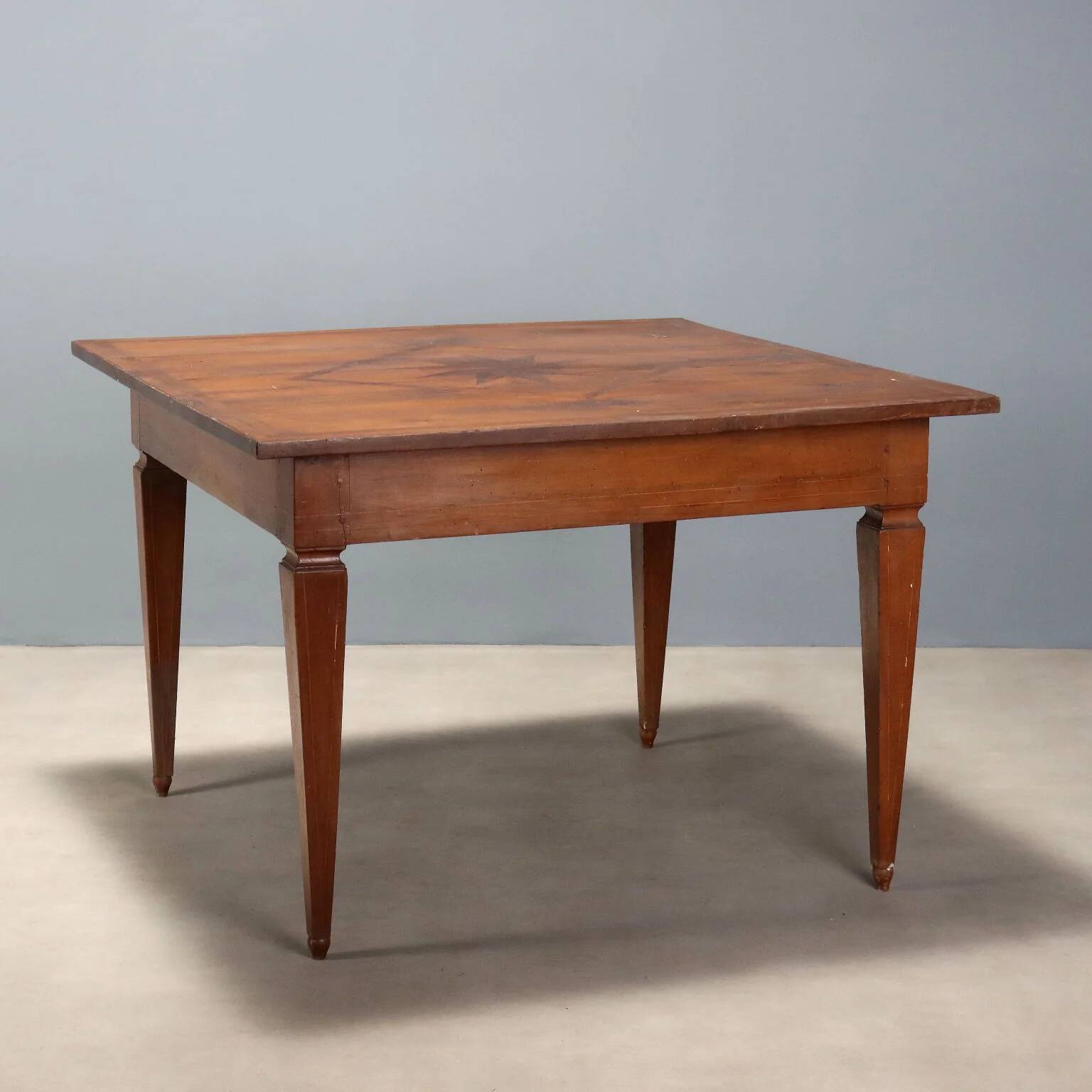 Antique Directoire table in walnut and cherry, Italy, 19th century.