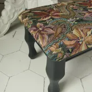 Petit ottoman repose-pied tapisserie vintage.