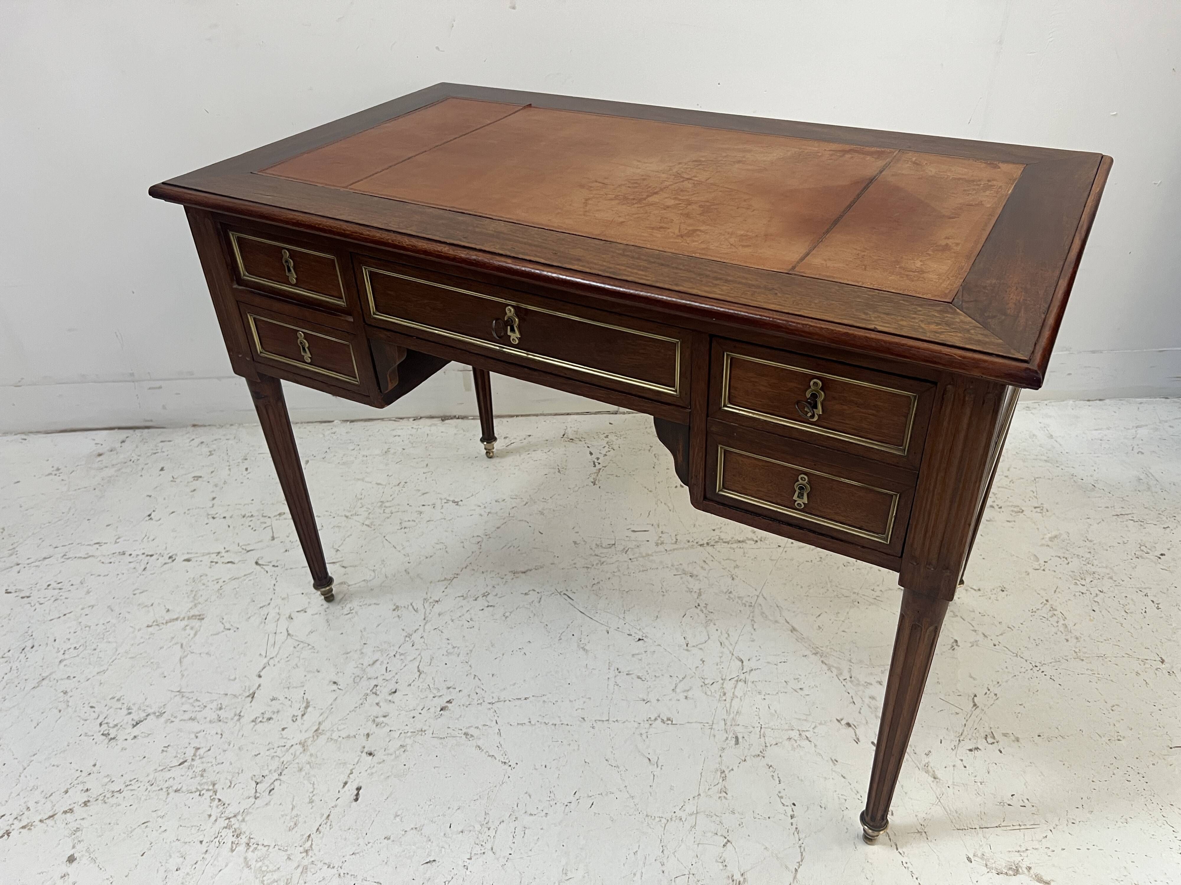 Louis XVI style desk in mahogany and mahogany veneer, 20th century.