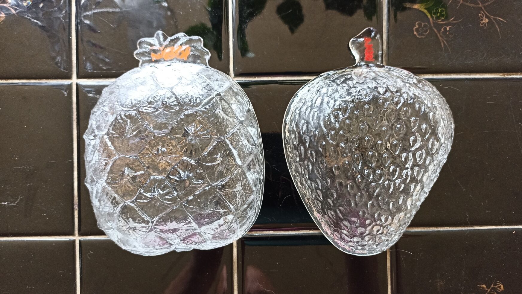 Two molded glass cups in the shape of strawberry and pineapple