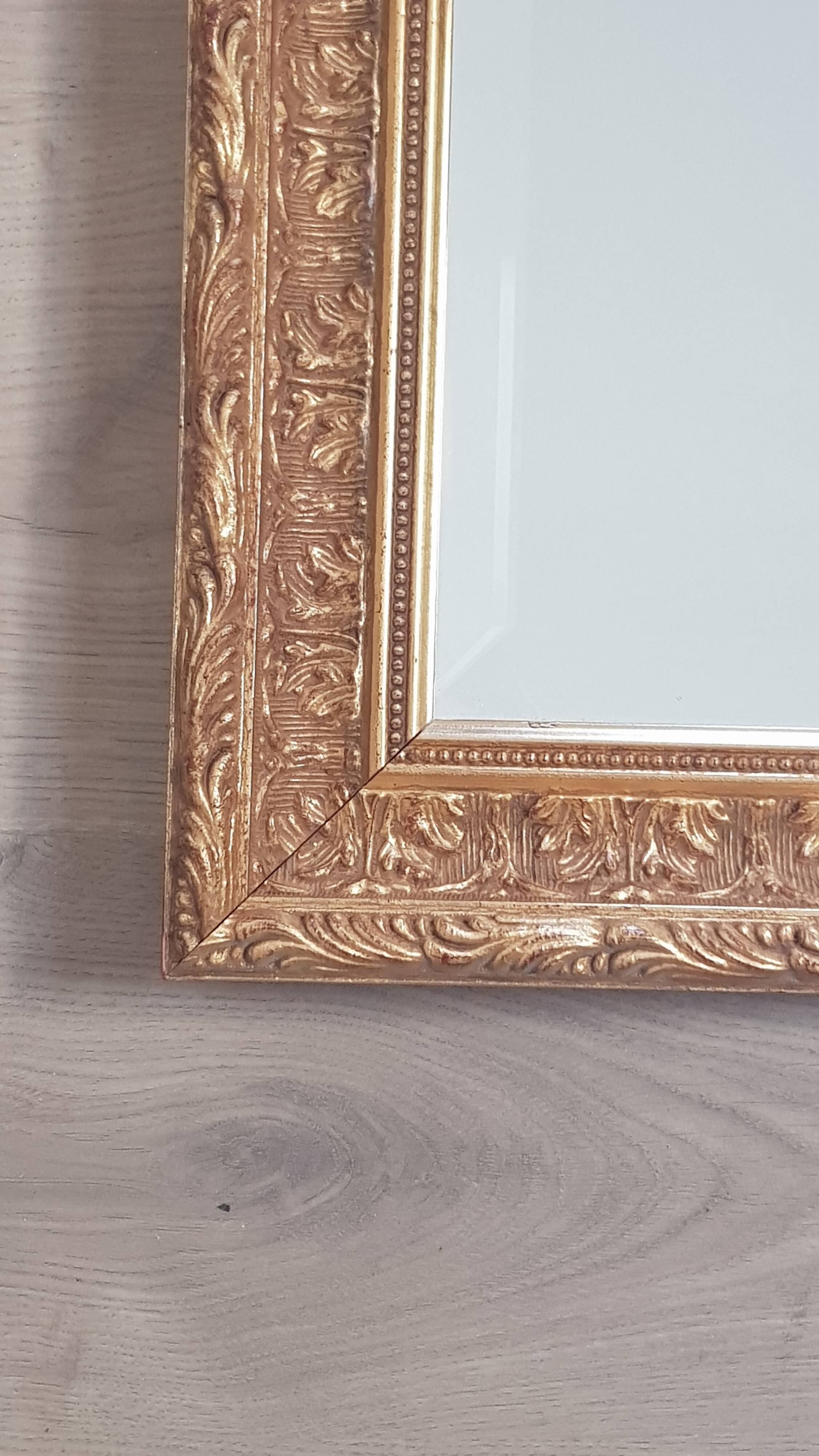 Mirror in gilded stucco wood and beveled glass