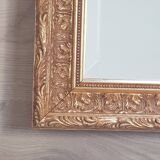 Mirror in gilded stucco wood and beveled glass