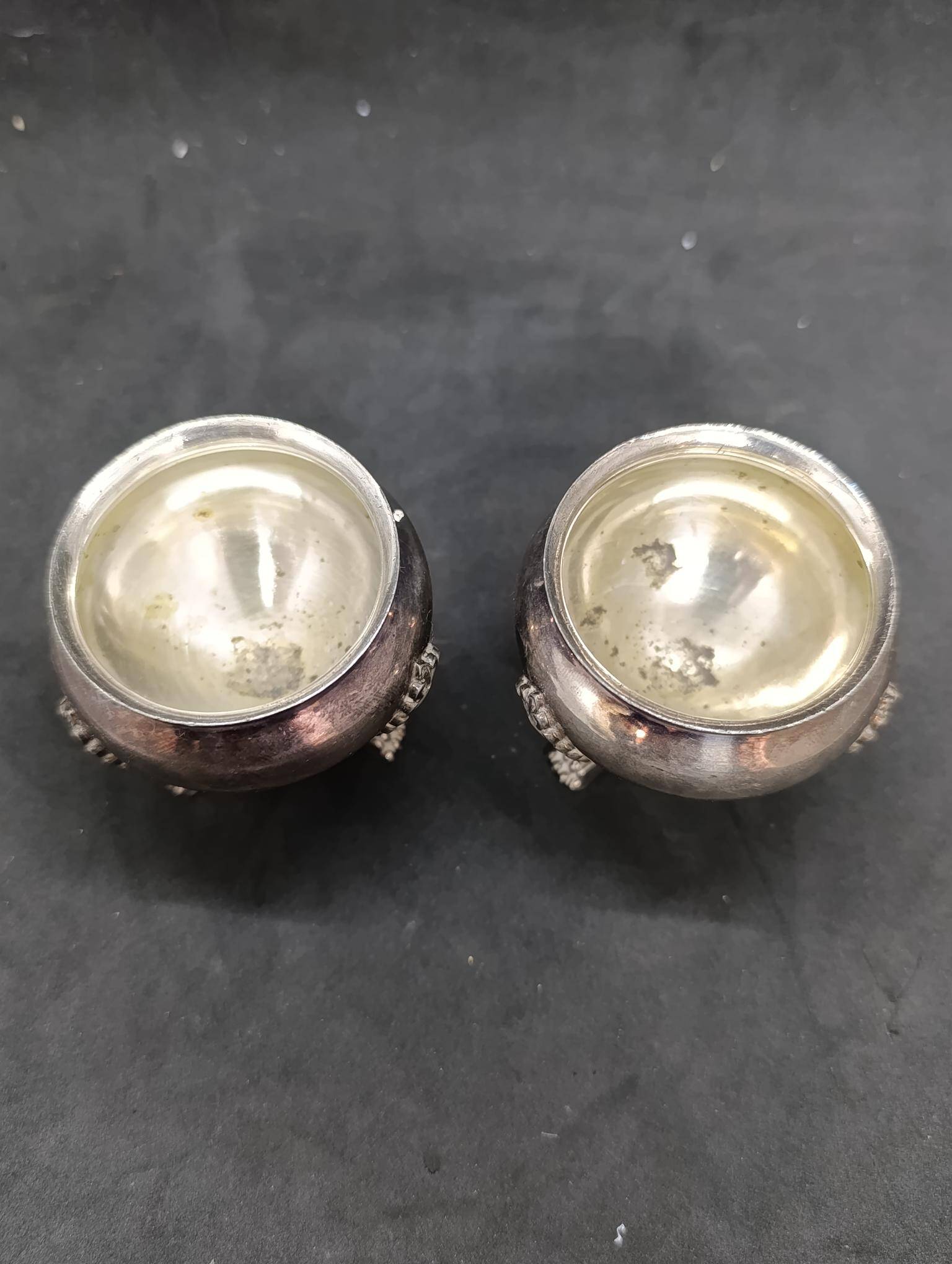 Pair of silver metal salt cellars with lion decor base