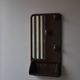 Wall mirror in moulded plastic with hooks and shelf.