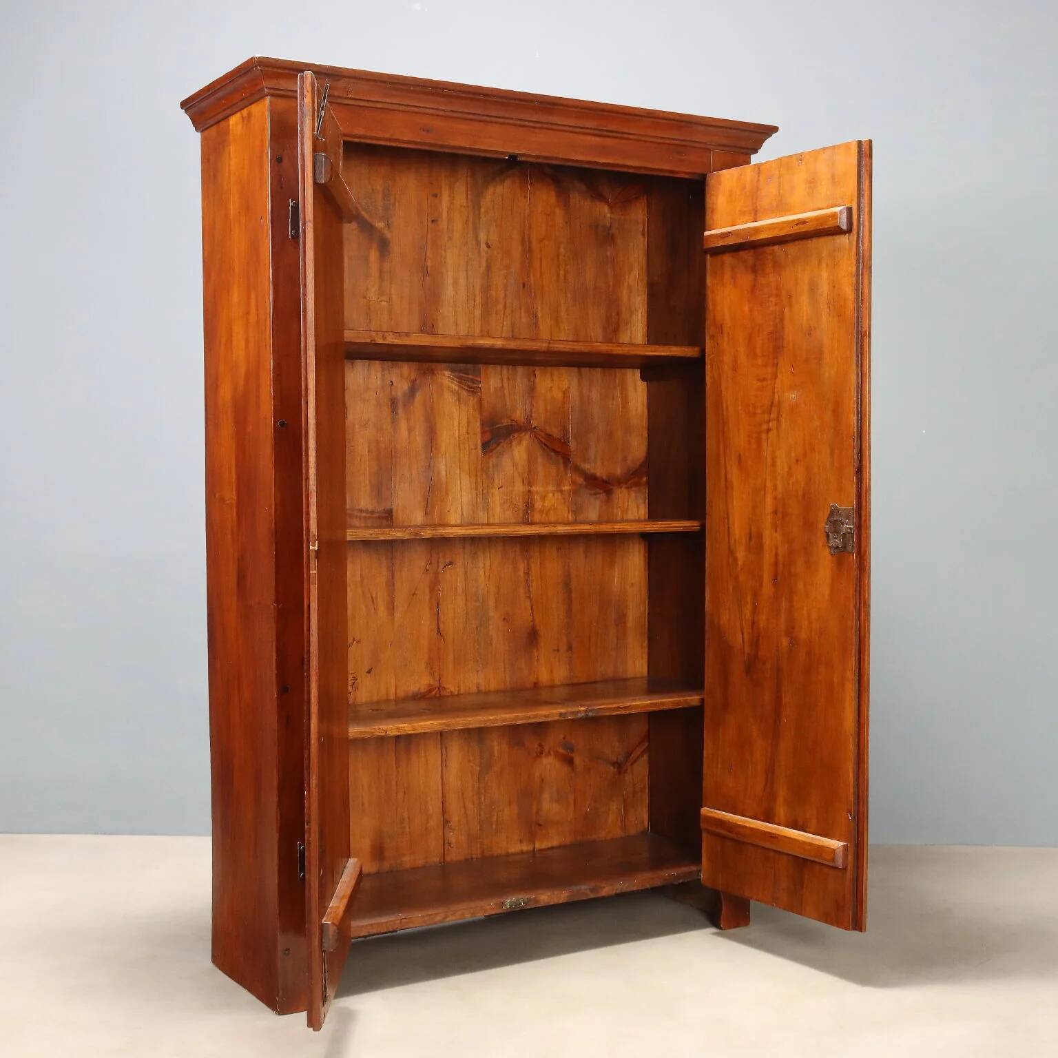 Vintage walnut wardrobe with exposed hardware.