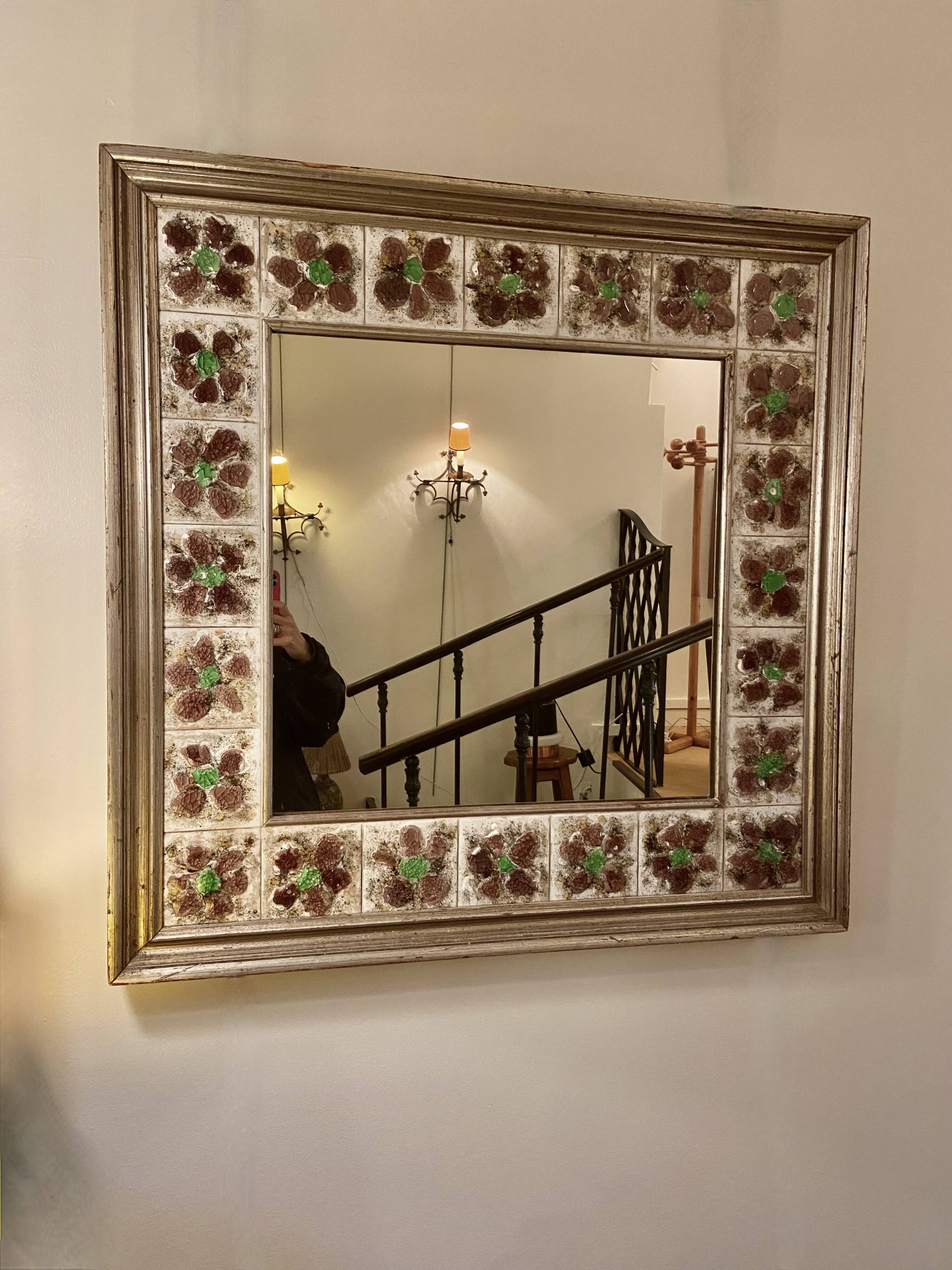 Large square ceramic mirror with floral decoration.