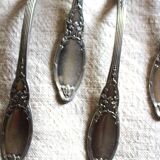 A set of 6 silver-plated metal soup spoons with foliage design.