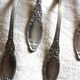 A set of 6 silver-plated metal soup spoons with foliage design.