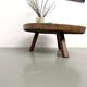 Brutalist coffee table in solid teak, monolithic slab, tripod base.