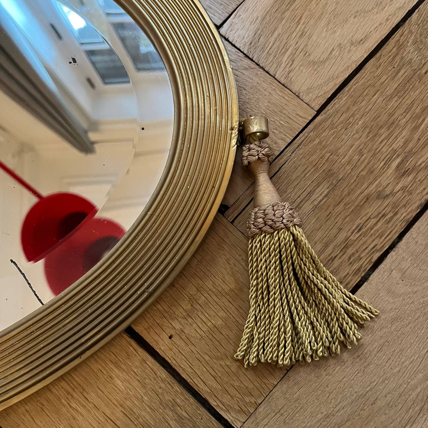 Antique oval beveled mirror adorned with tassels