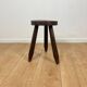 Small brutalist tripod stool in solid wood.