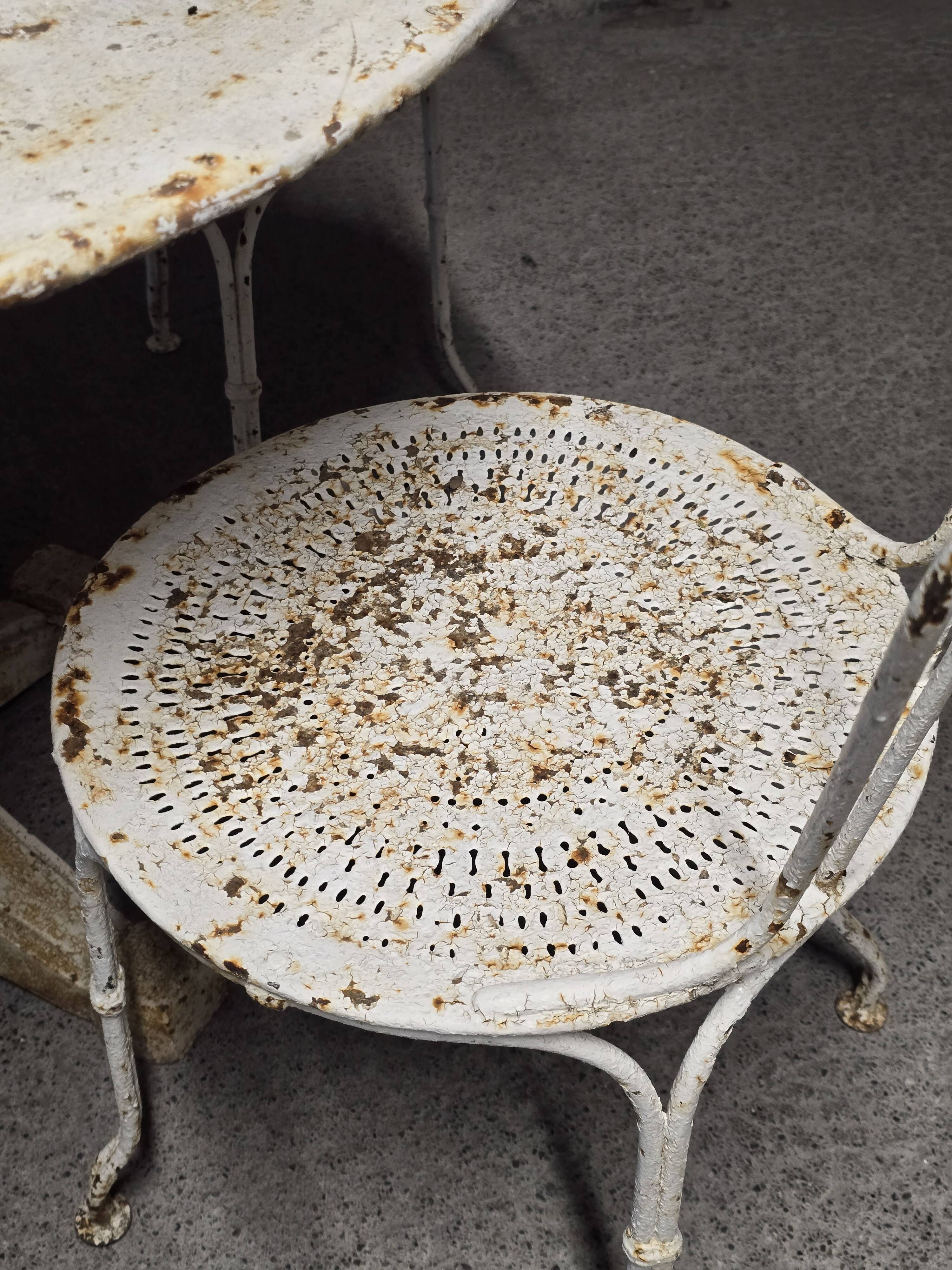 Antique painted wrought iron garden furniture, round table and four chairs.