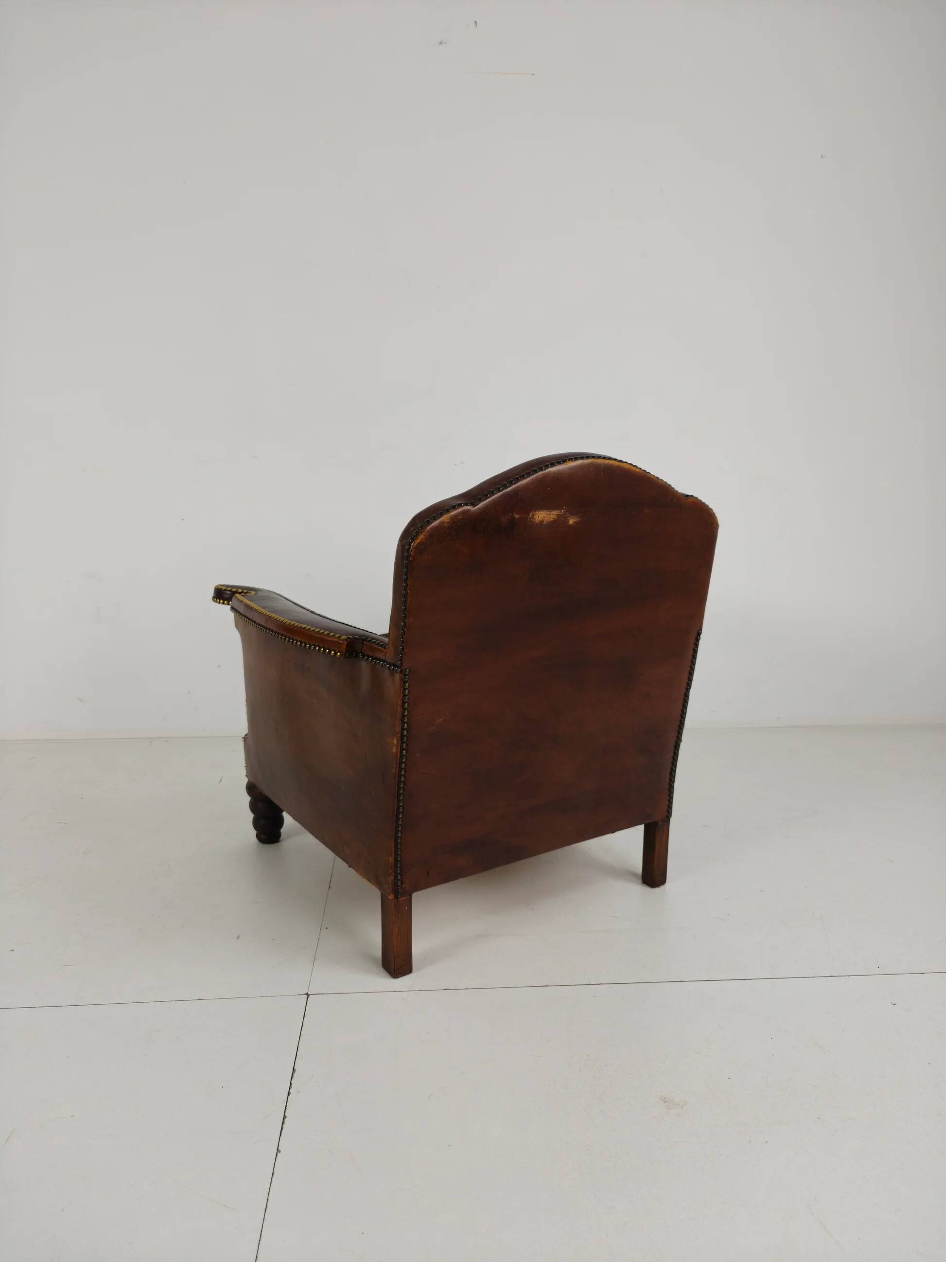 Antique leather club chair with stud detailing