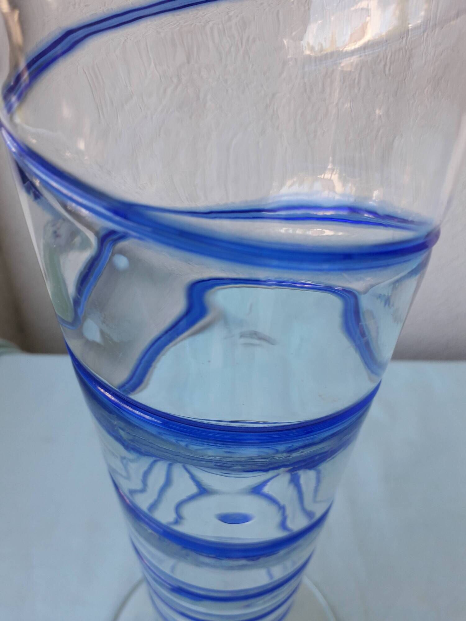 Glass vase on a pedestal with a blue trim.