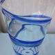 Glass vase on a pedestal with a blue trim.