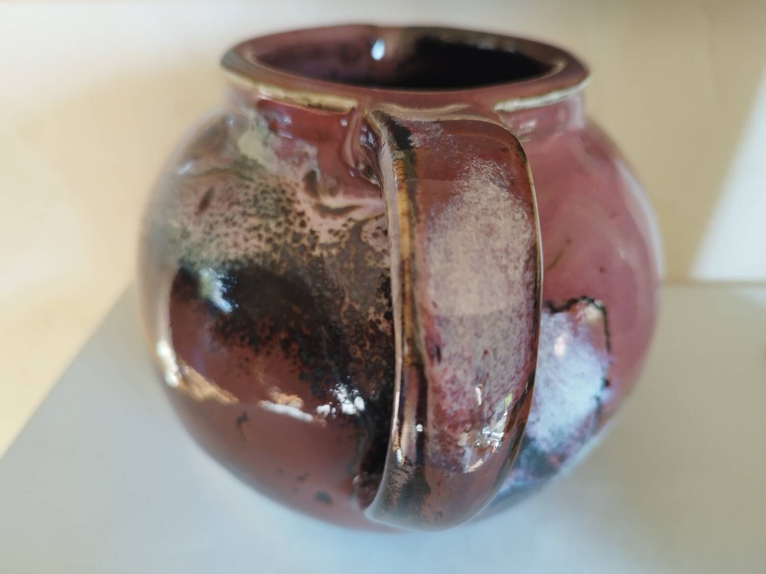 Stoneware pitcher by Matthieu Liévois in shades of red