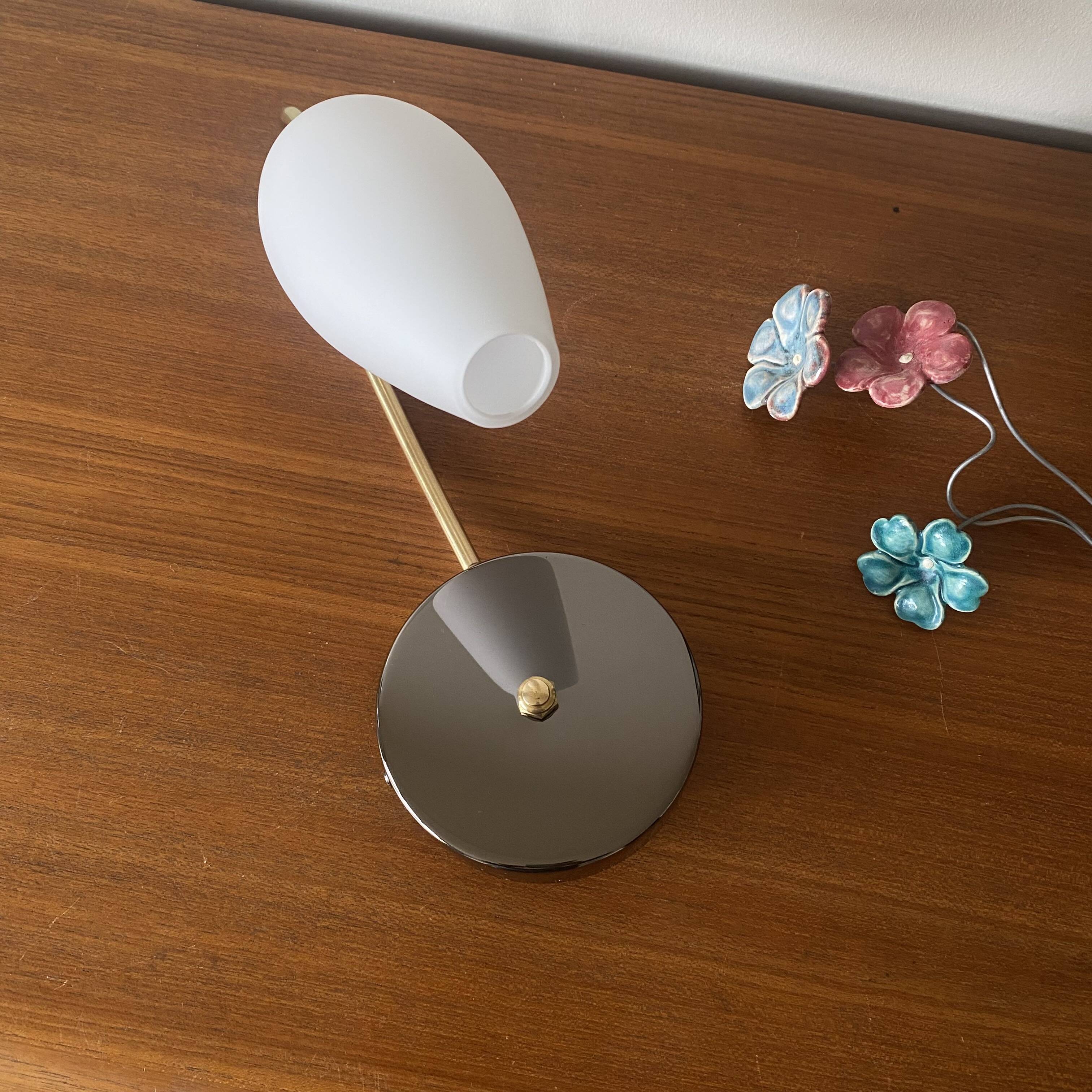 Swan neck wall light in brass and white opaline glass tulip.