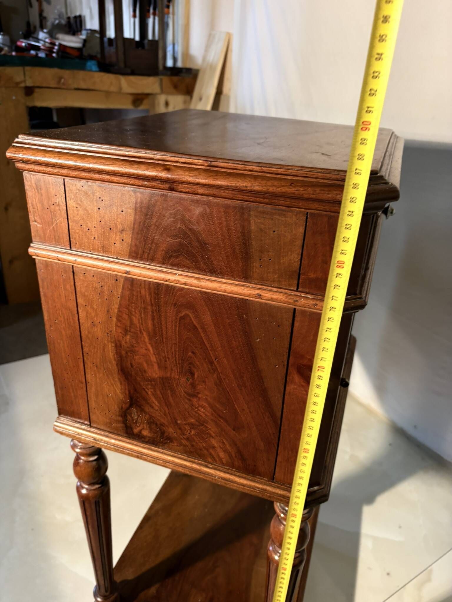 Antique wooden bedside table with turned legs.