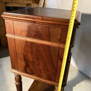 Antique wooden bedside table with turned legs.