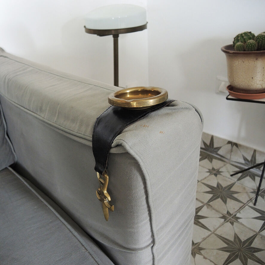 Old armrest ashtray with fleur-de-lis design in leather and brass.
