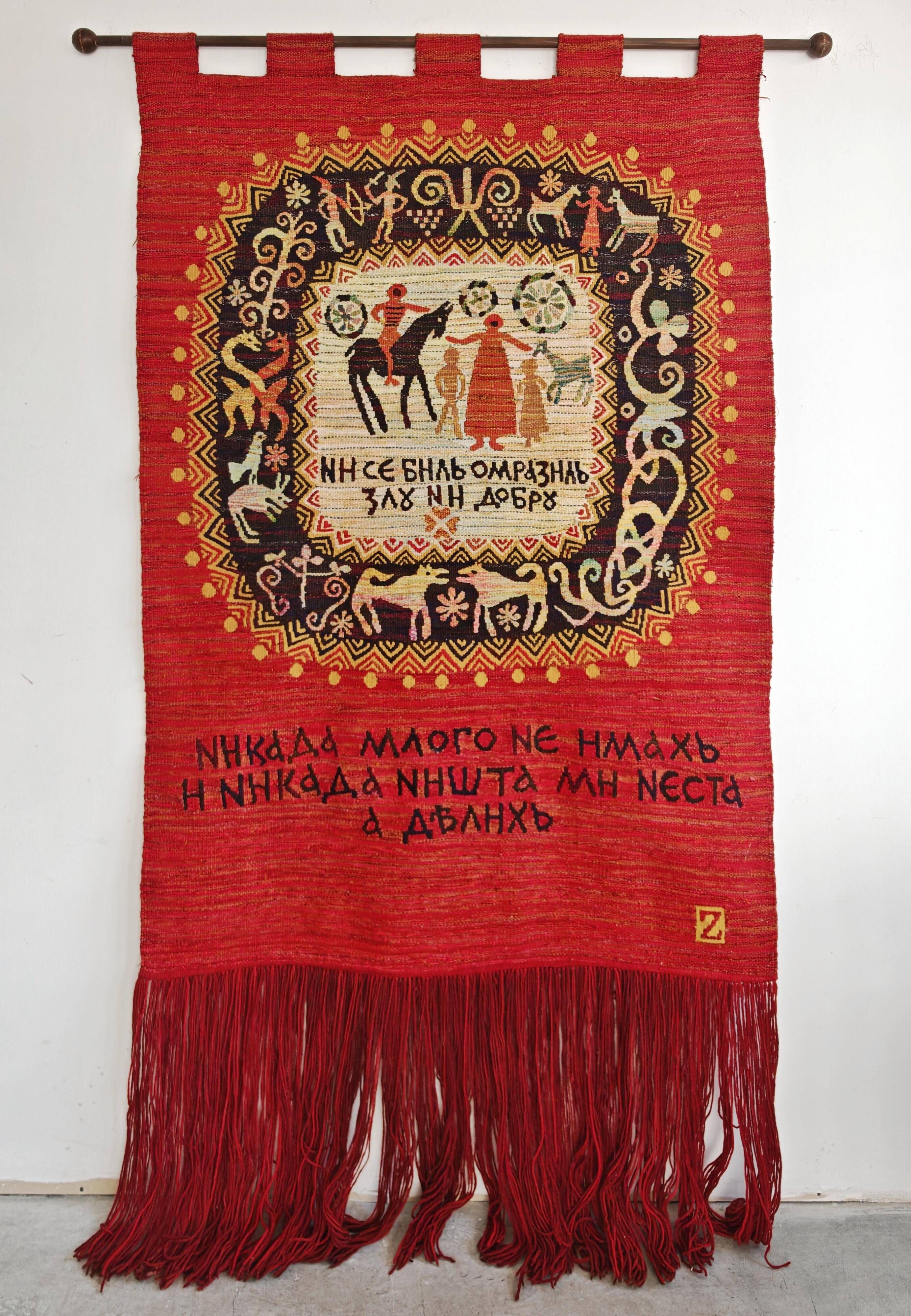 Vintage handwoven tapestry with a folk scene and archaic Slavic writing.
