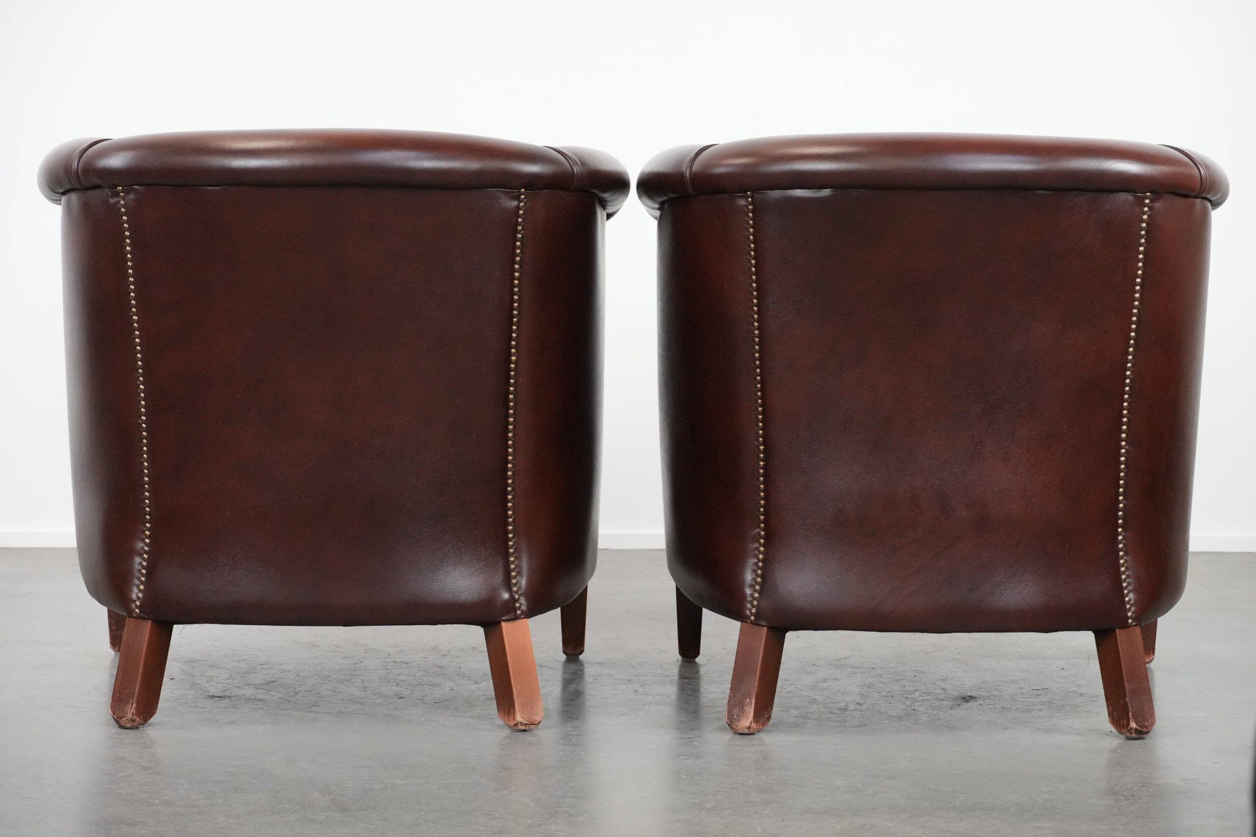 Set of two cow leather club armchairs in a luxurious red/brown colour