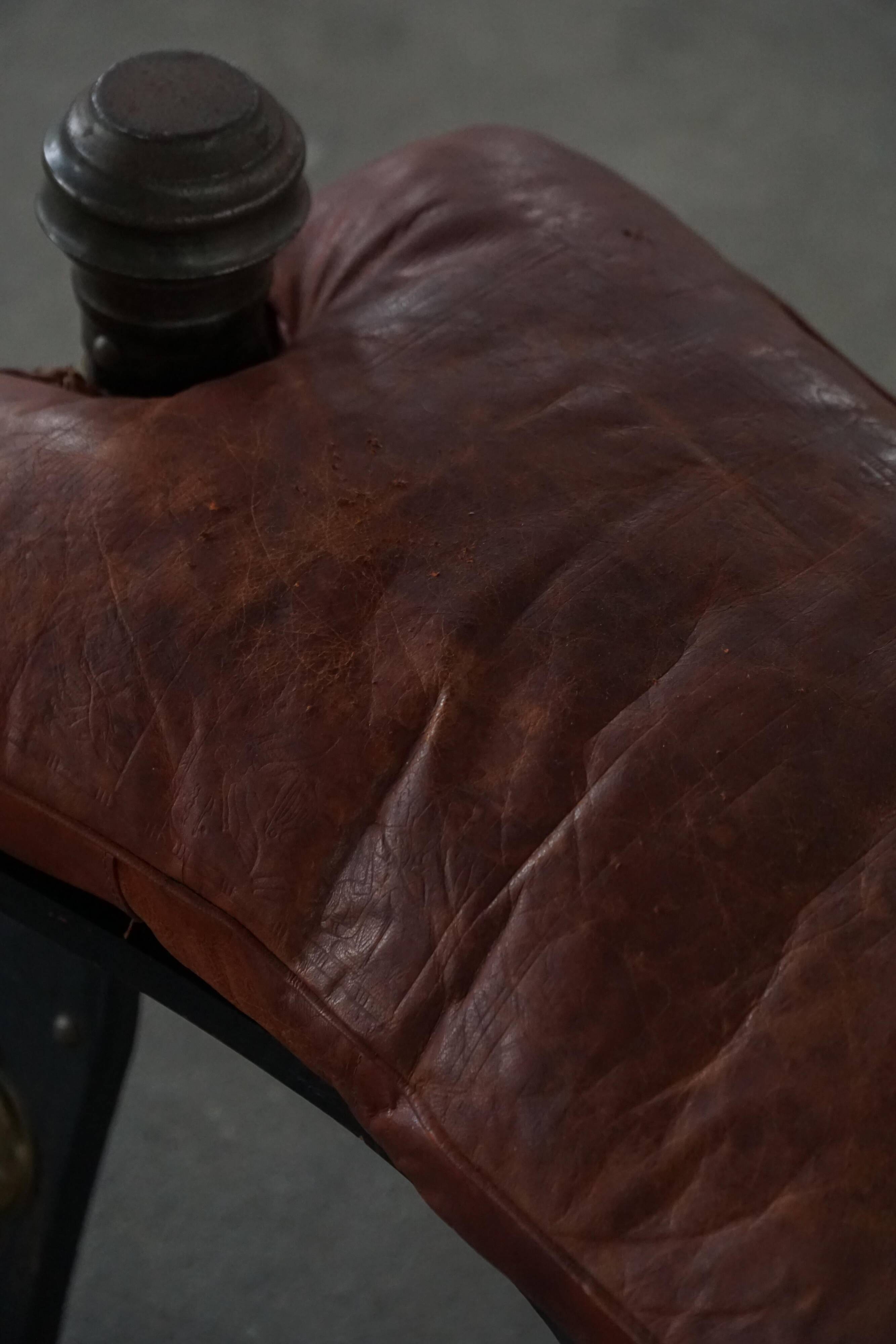 Dark red upholstered camel saddle stool, 20th century, North Africa.