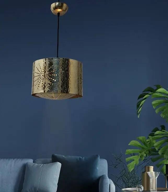 Hammered copper metal pendant light with a golden cylindrical shade.