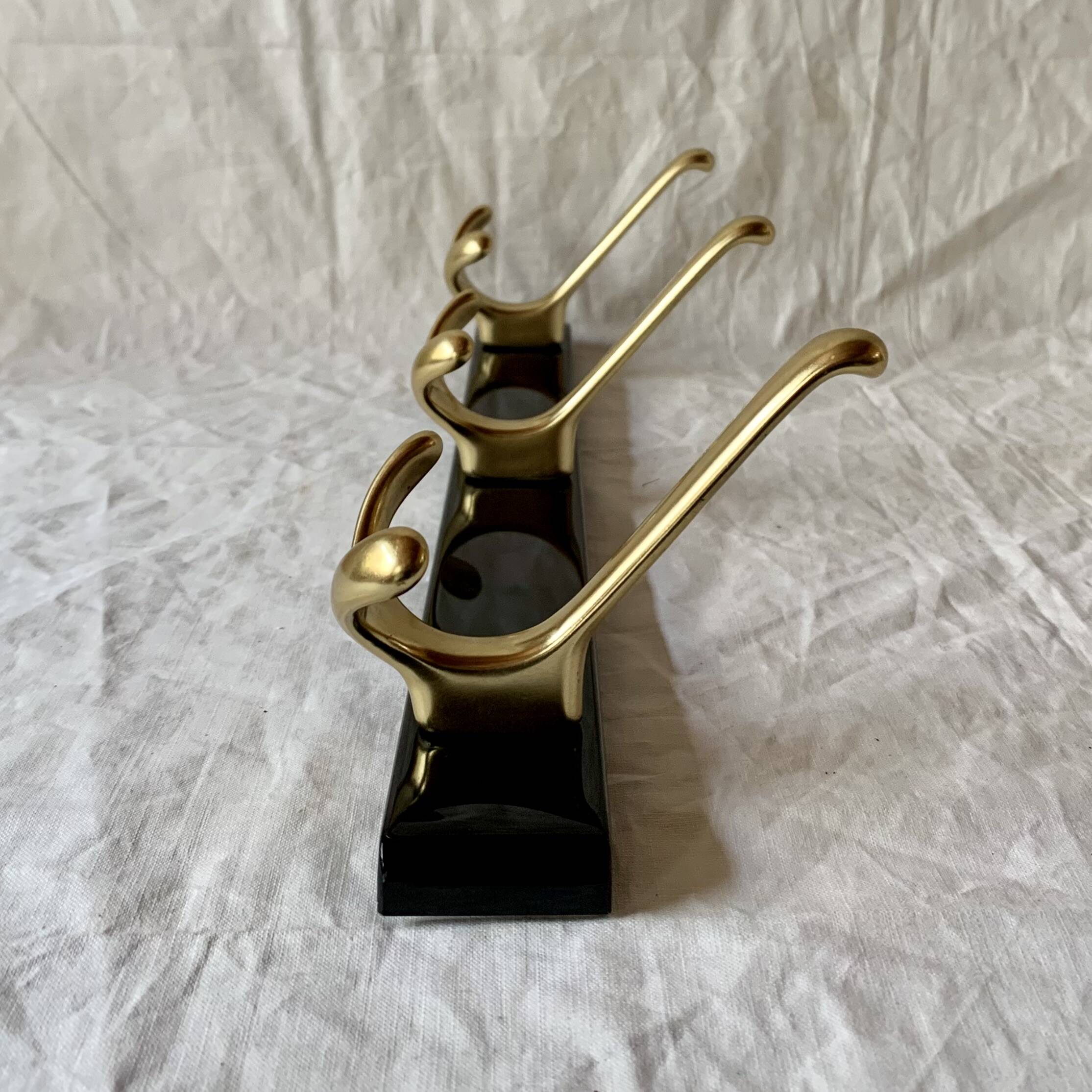 Vintage coat rack in lacquered metal with three golden aluminum hooks