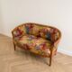 Two-seater banquette in Louis XV style made of wood and floral fabric.