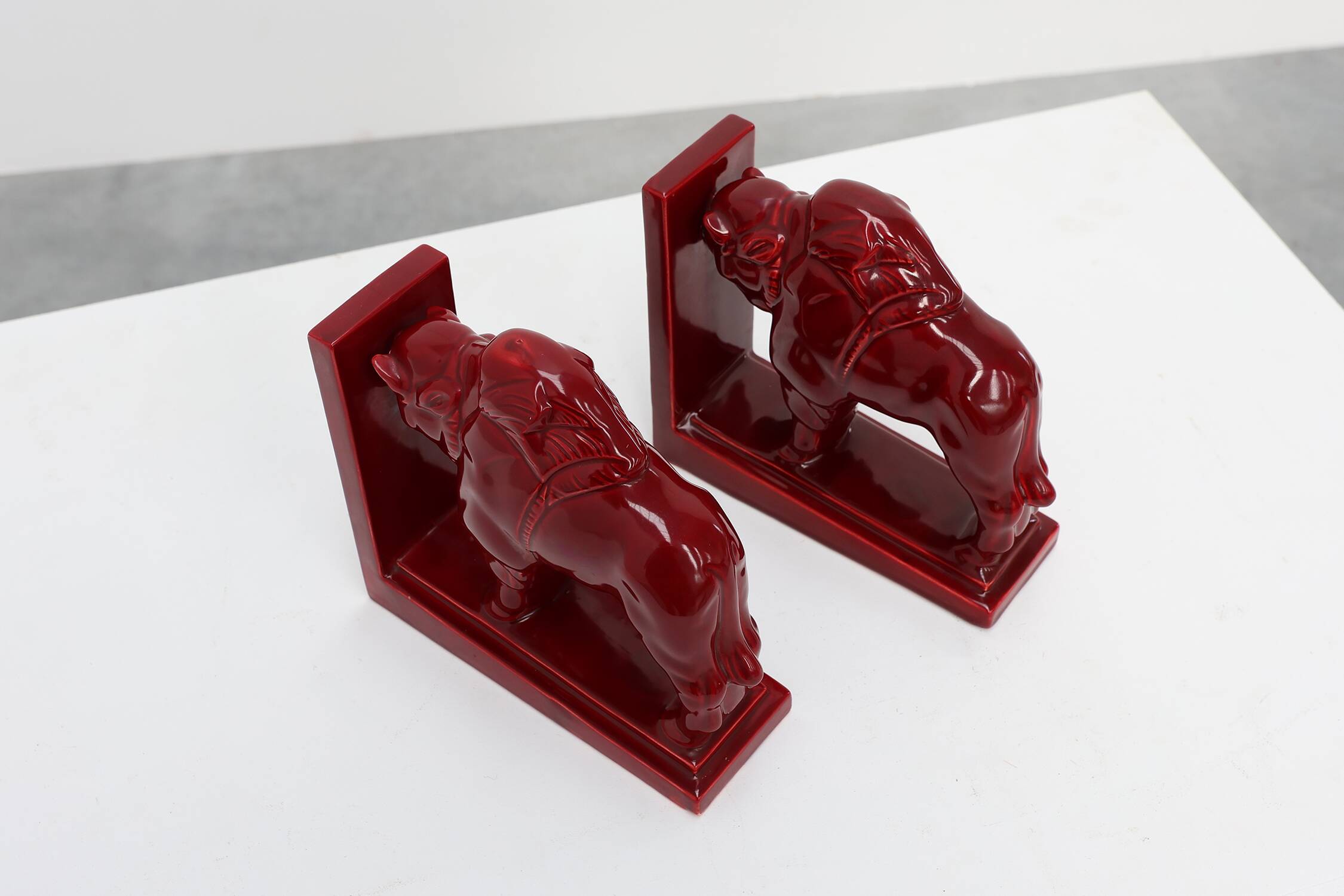 Pair of red glazed ceramic Bison ox bookends in Art Deco style, Belgium