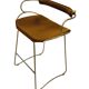 Bar stool with a vintage brass backrest and natural brown leather.
