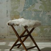 Folding stool, reupholstered in long-haired sheepskin, mid-century modern style, 1950s.