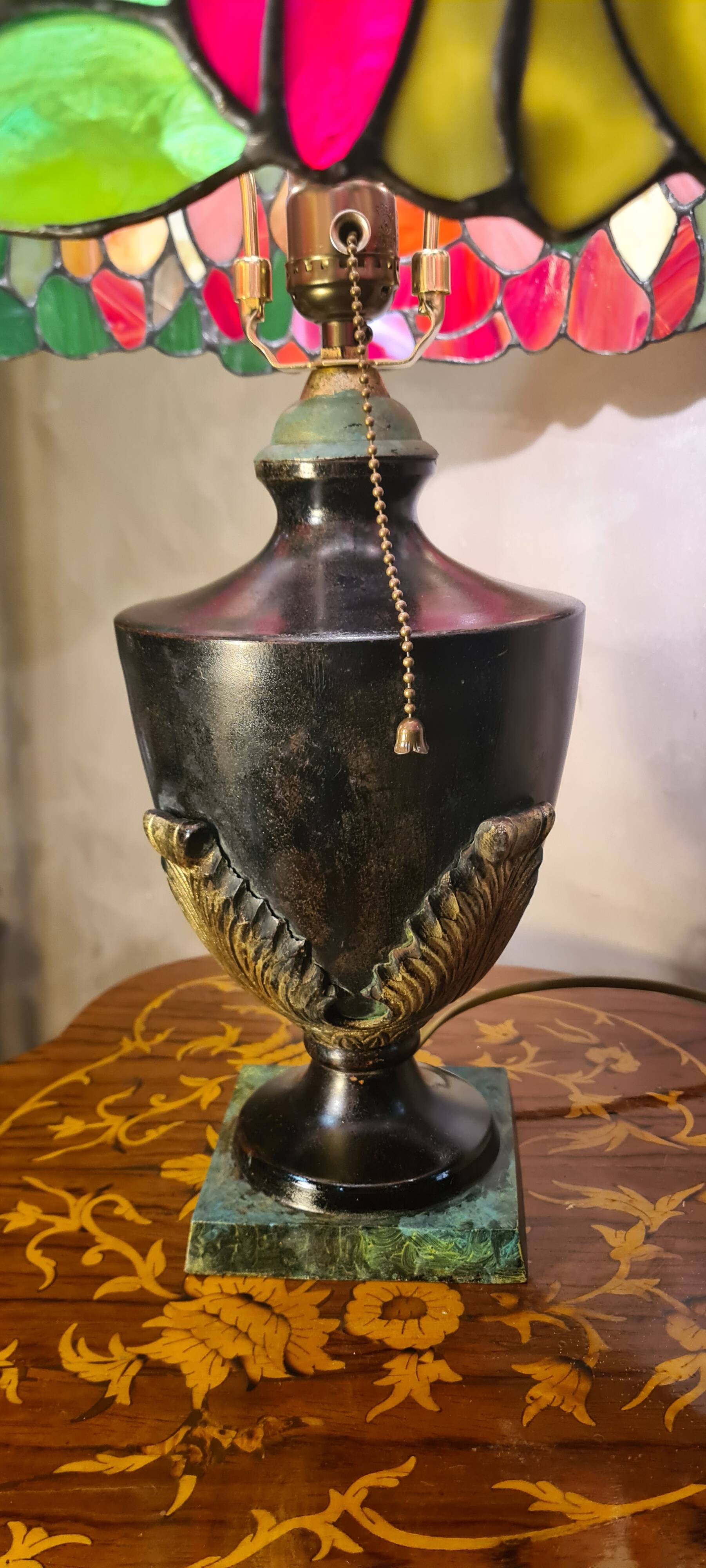 antique patinated cast iron lamp with a glass paste lampshade, showing signs of wear.