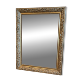 Golden mirror with an antique wooden and stucco frame.