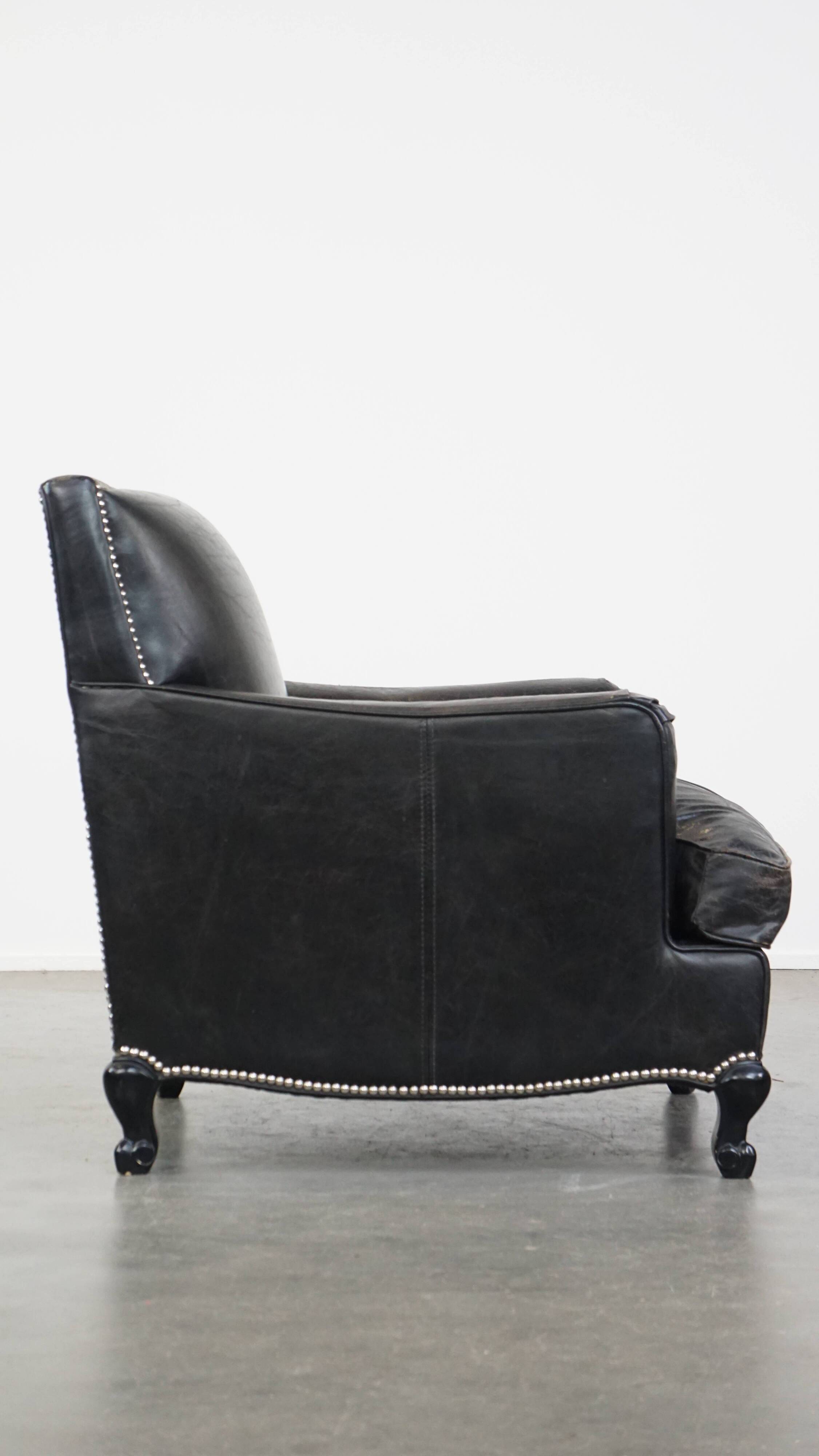 Armchair in black grained cowhide leather with a deep seat