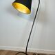 Design floor lamp in black lacquered metal and brass.