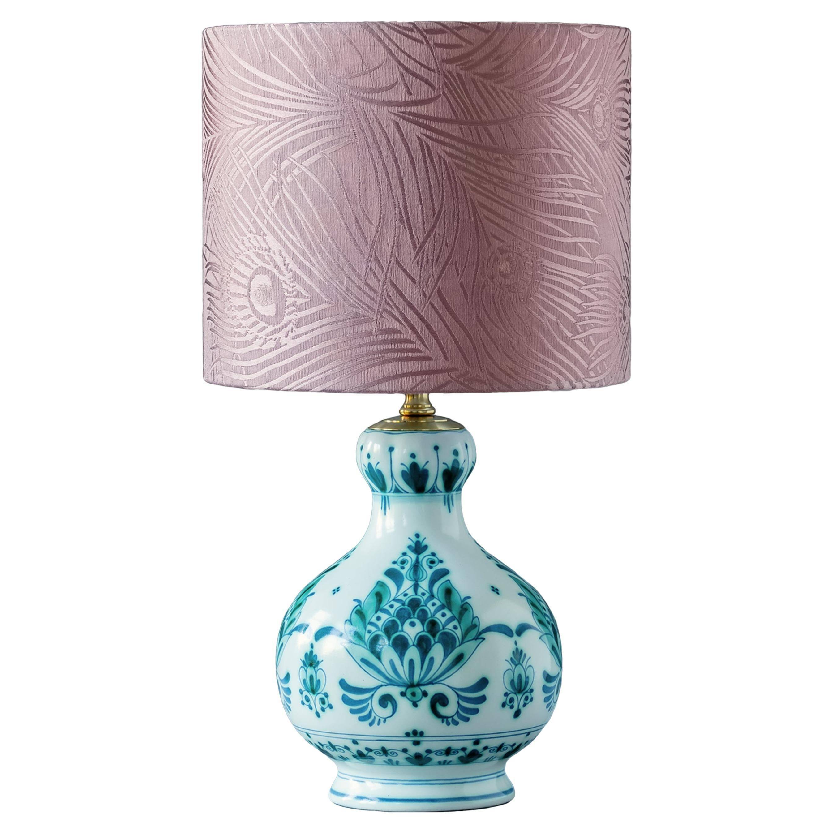 Royal Delft blue-green ceramic table lamp with pink jacquard peacock shade.