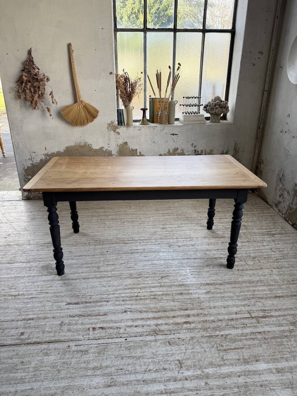 Oak farmhouse table with turned black legs.