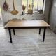 Oak farmhouse table with turned black legs.