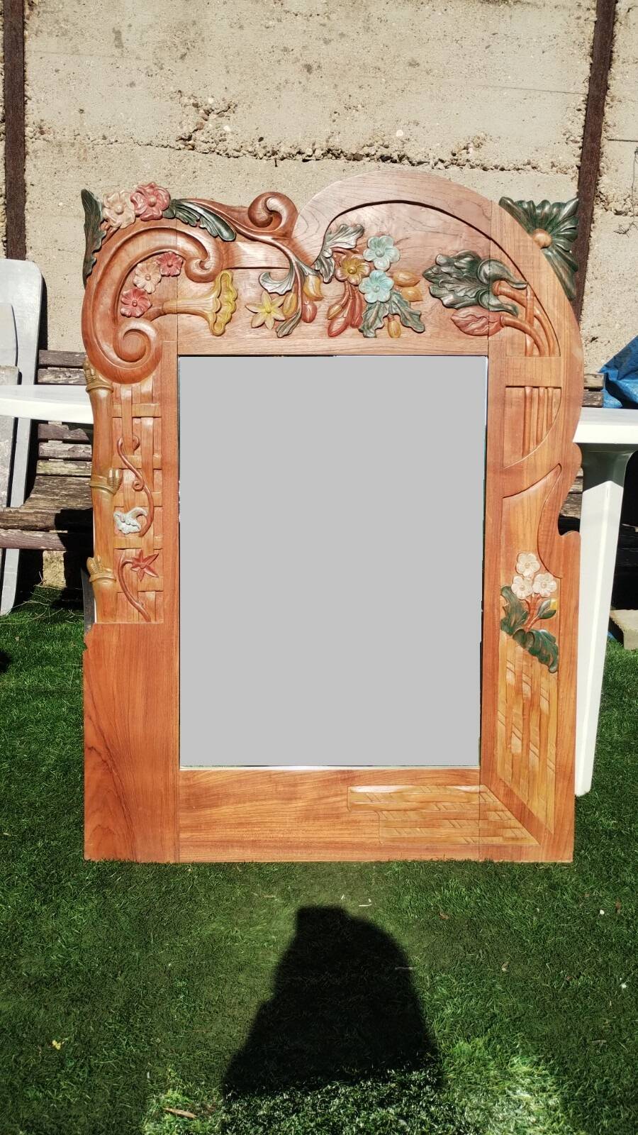 Pretty beveled mirror with wooden frame and floral decoration.