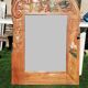 Pretty beveled mirror with wooden frame and floral decoration.