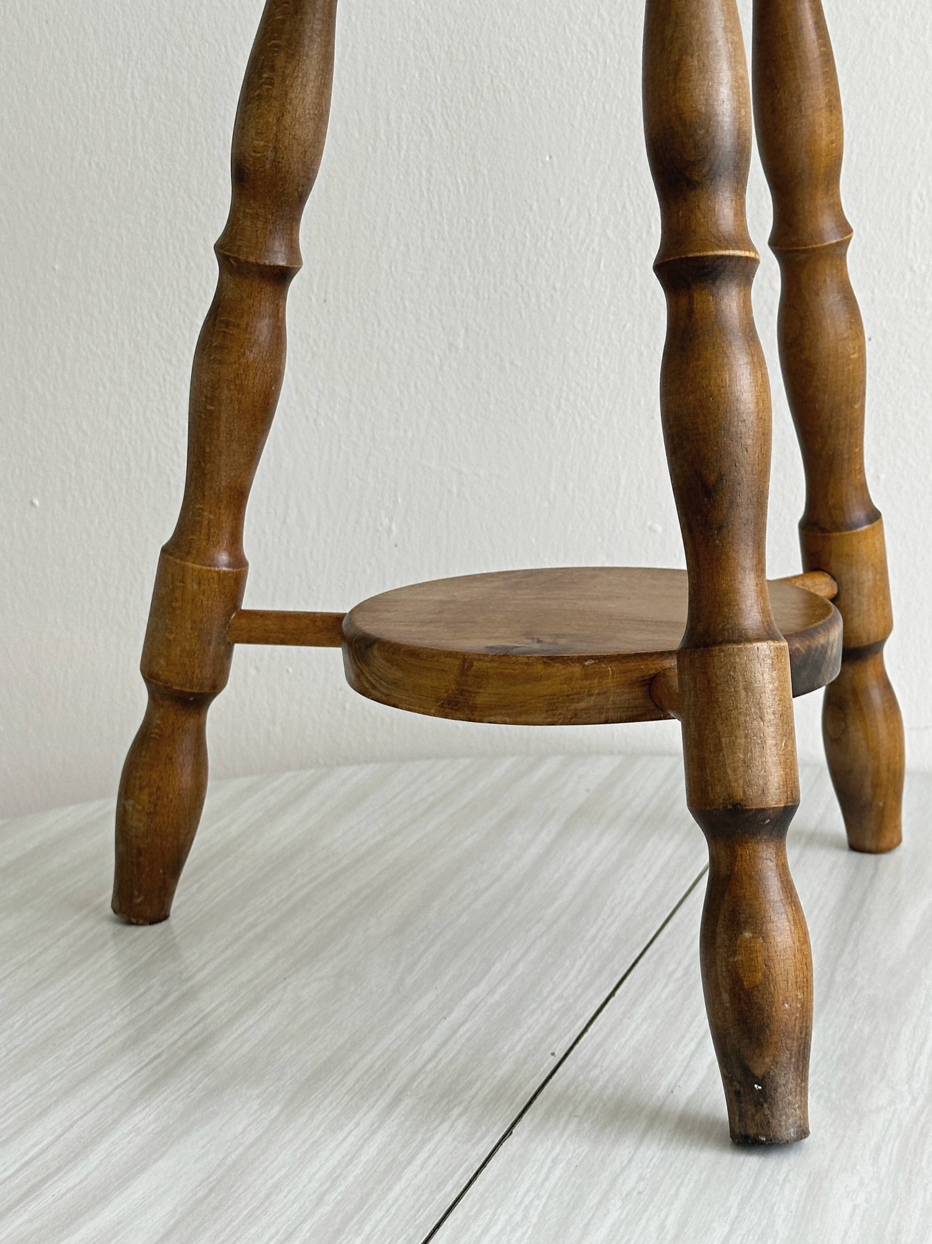 Tabouret vintage en bois tourné avec tablette basse