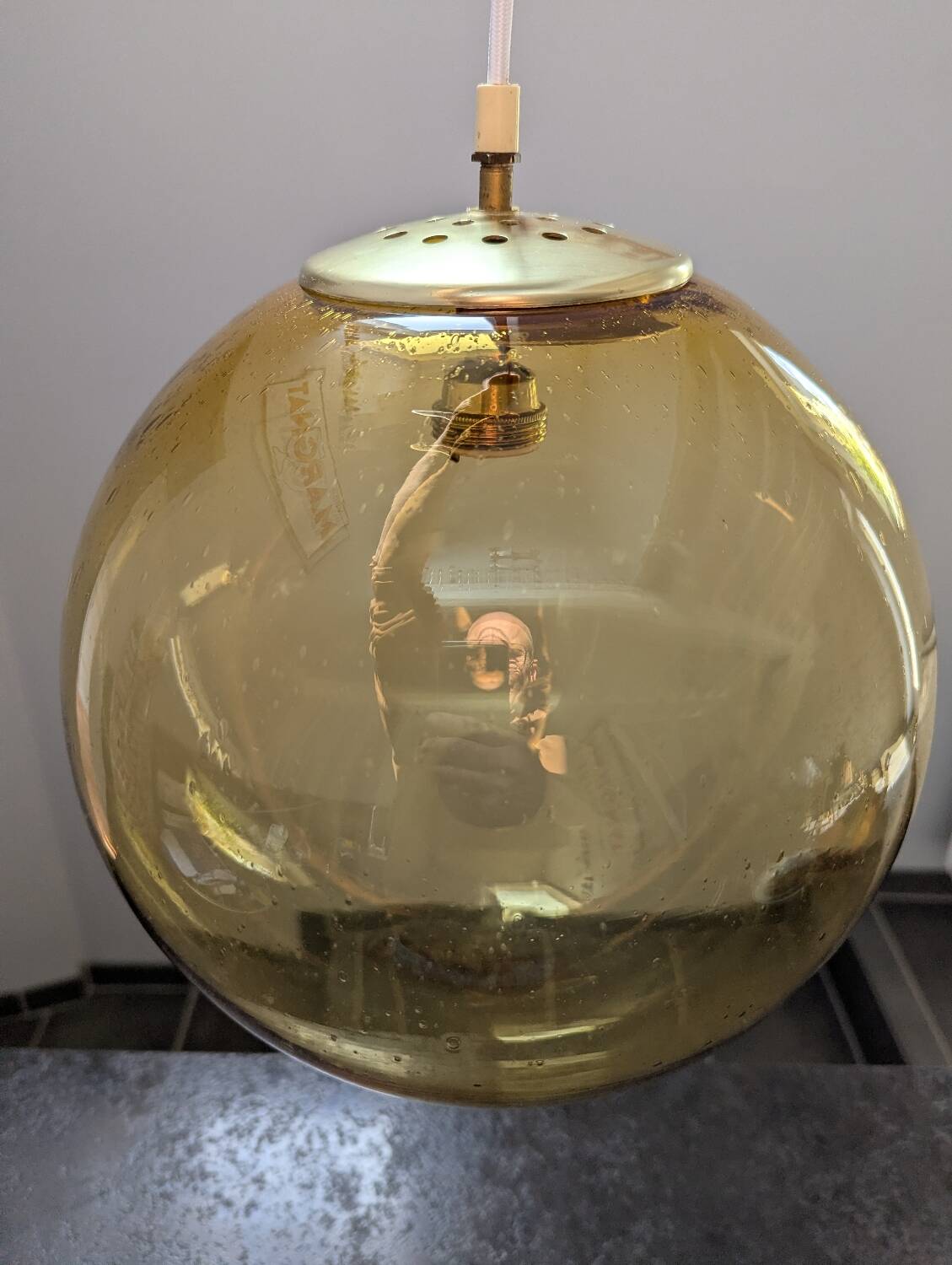 Old large and imposing thick glass globe with a bubbled amber colour, vintage.