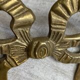 Two-hook coat rack with knot and ribbon in brass