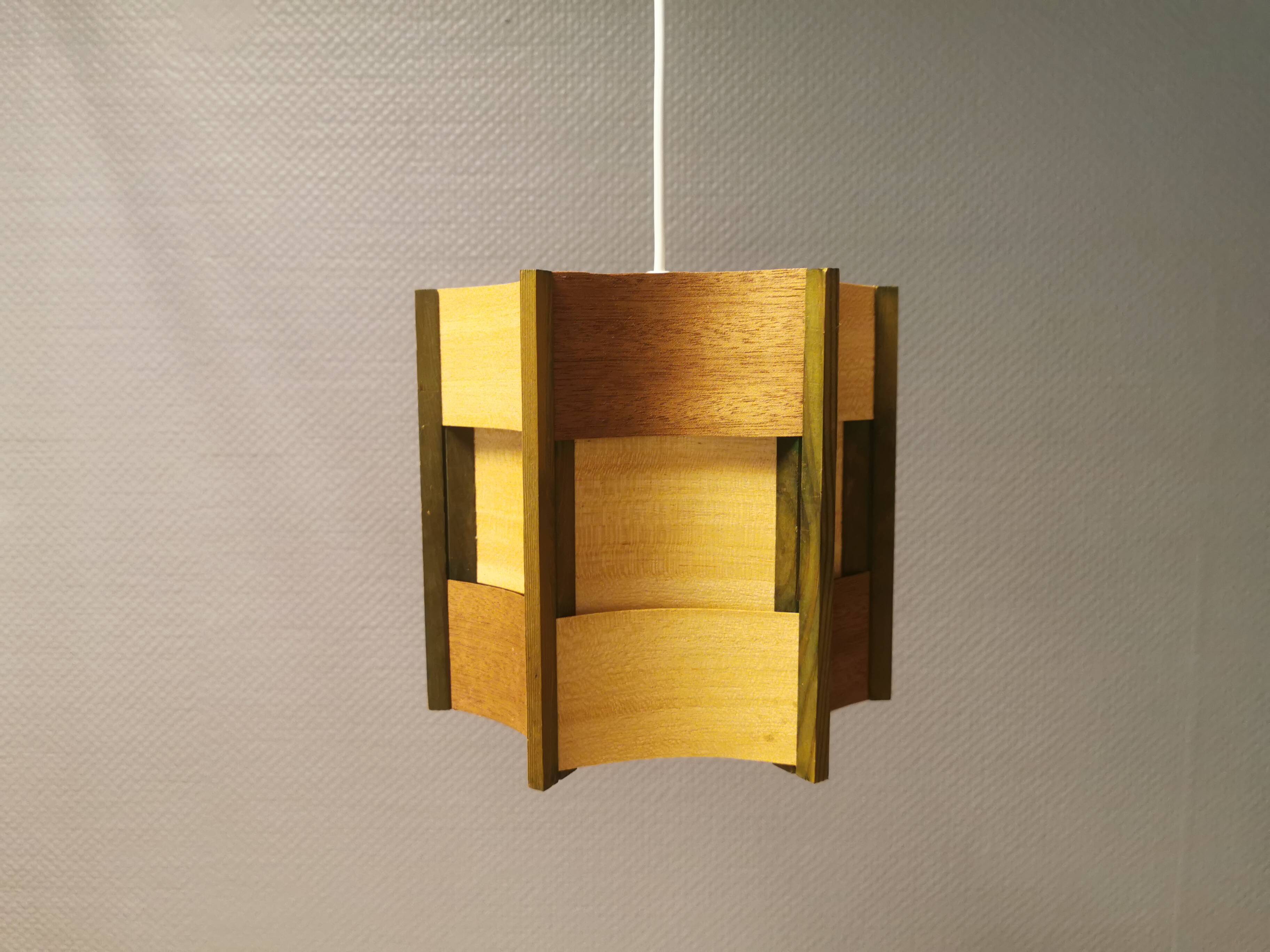 Older lamp in wood veneer, partially painted in green colour.