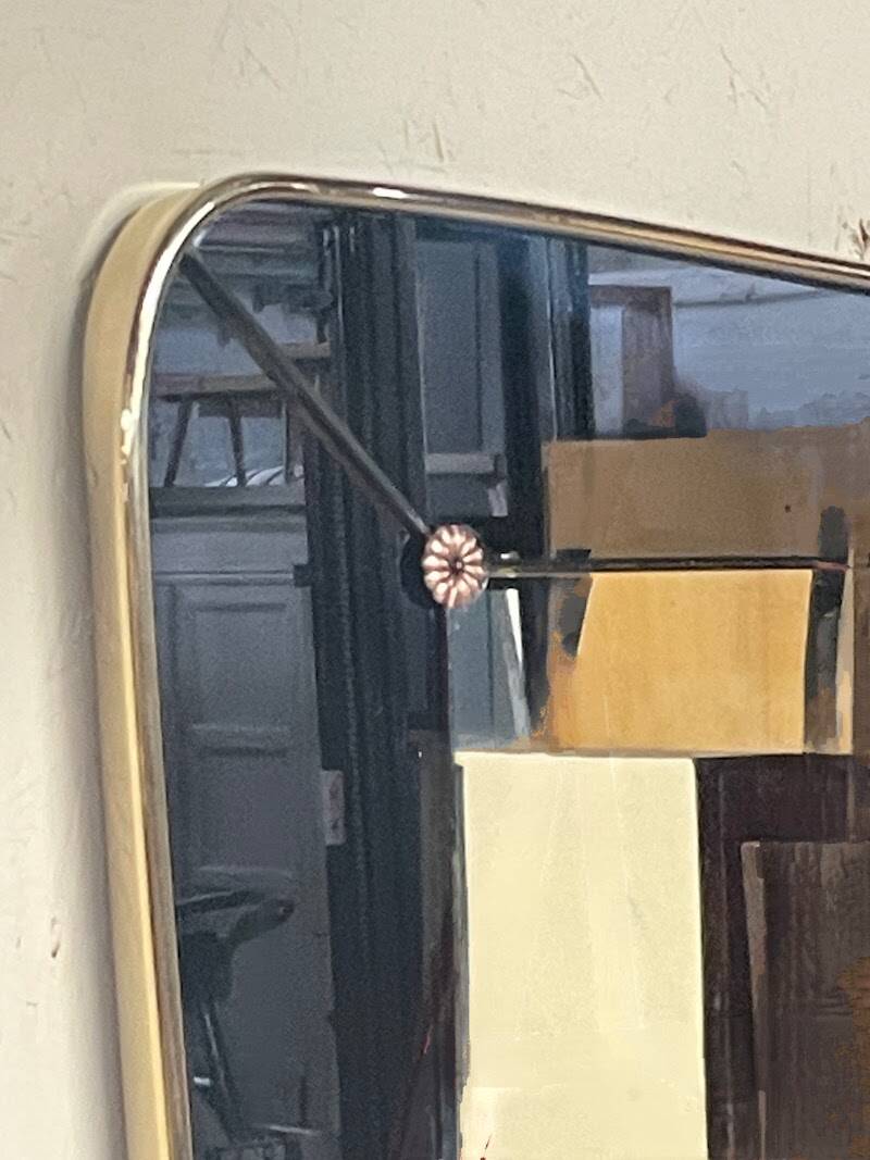 1950s double-thickness wall mirror with brass profile and supports.