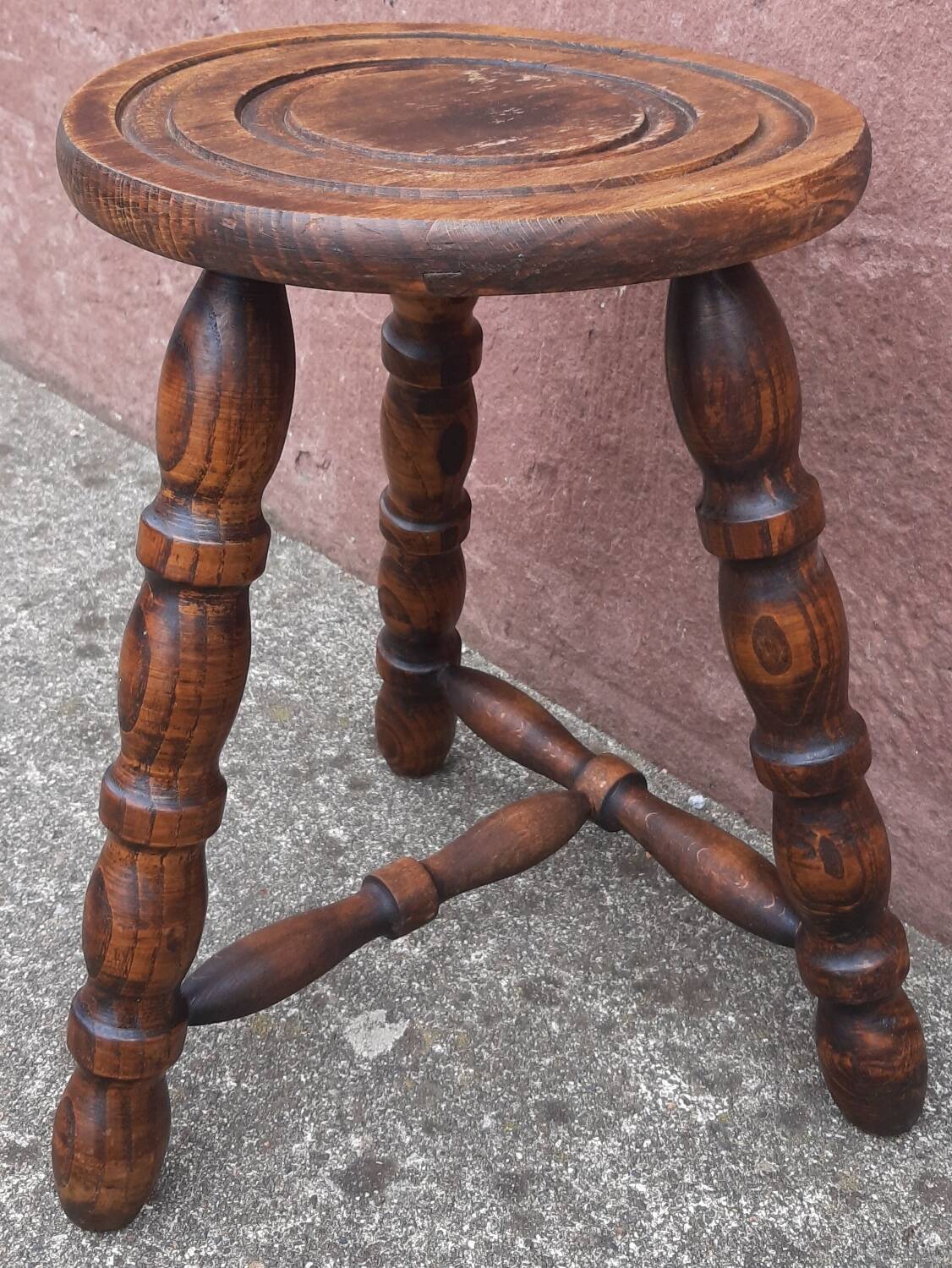 Low wooden tripod stool.