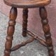 Low wooden tripod stool.